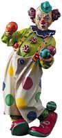 Eine Person in farbenfrohem Clownskostüm mit buntem Gesicht und großen Schuhen steht vor weißem Hintergrund.