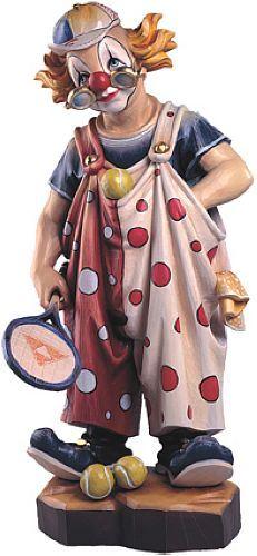 Eine Clownfigur mit roter Nase, braunen Haaren und gepunktetem Anzug auf einem Sockel