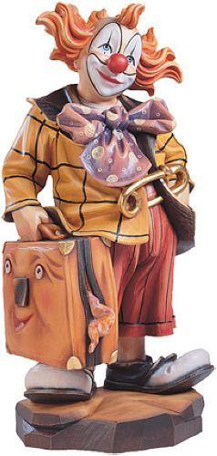 Figur eines Clowns mit roter Nase, orangefarbenen Haaren und Koffer